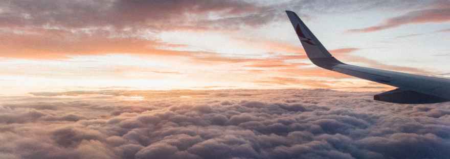 white airliner wing on top of sea clouds