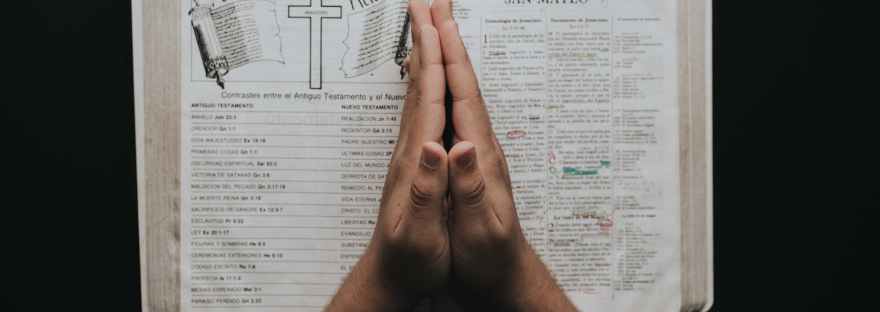 person placing hands on bible