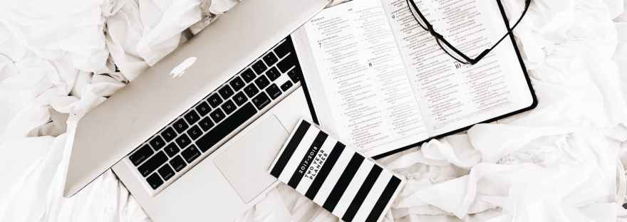 eyeglasses on book beside macbook
